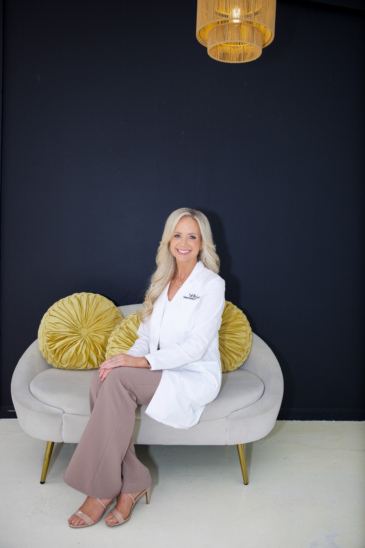 Brittany Stanley in a white coat seated on a couch